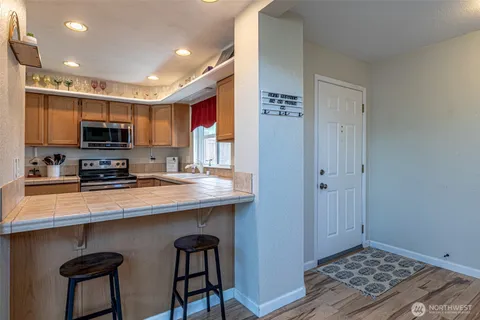 a kitchen with stainless steel appliances a sink a stove a microwave a refrigerator a counter top and oven