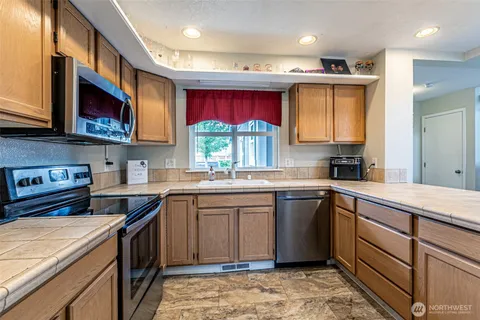 a kitchen with stainless steel appliances granite countertop a stove a sink dishwasher and a microwave