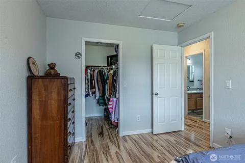 a view of a hallway with wooden floor and closet