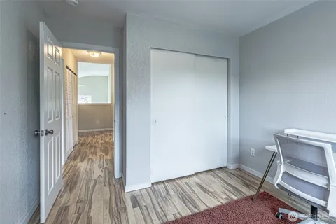 a view of a bedroom with wooden floor