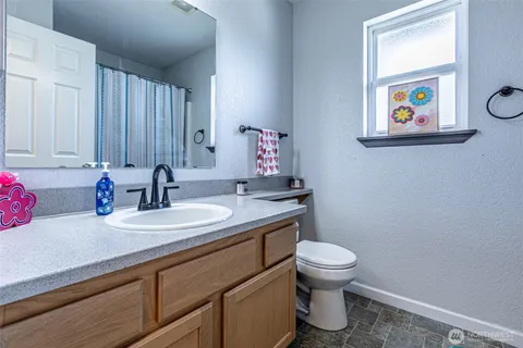 a bathroom with a toilet a sink and mirror