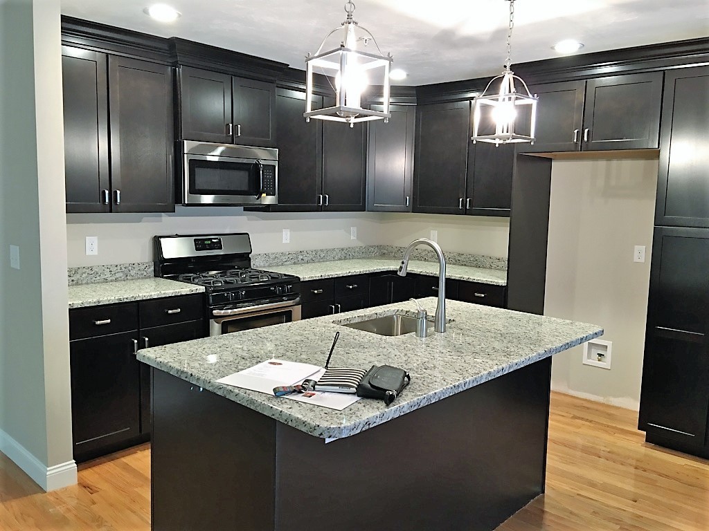 3 Trail Ridge Way, Unit 3A Harvard, MA 01451 - Photo 8 of 19 a kitchen with stainless steel appliances granite countertop a sink refrigerator and microwave