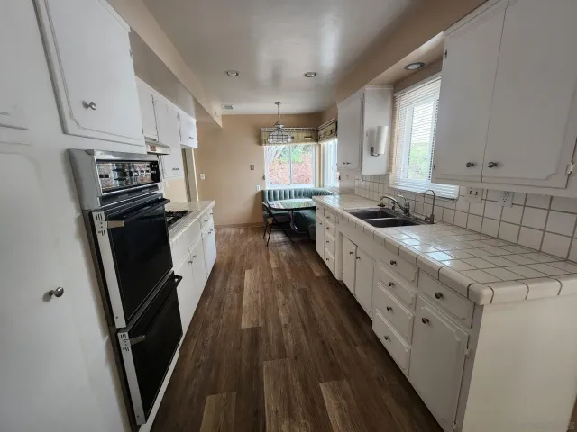 a kitchen with granite countertop a sink stove and refrigerator