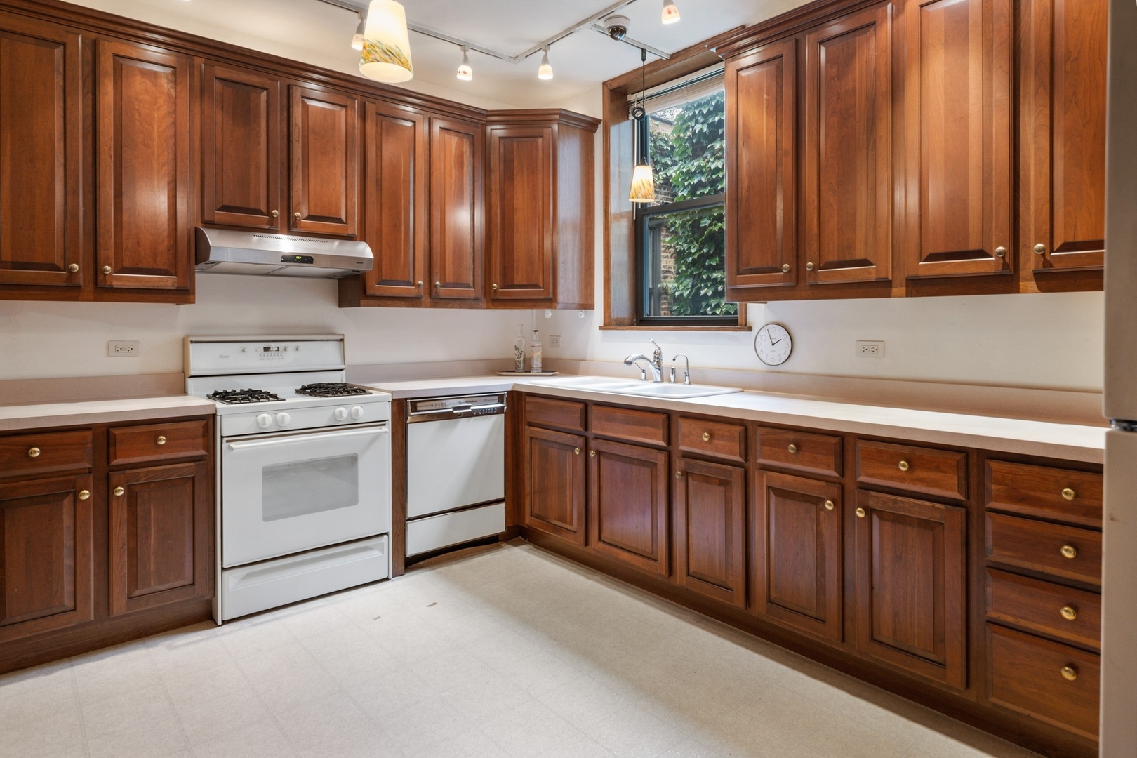 731 West Junior Terrace Chicago, IL 60613 - Photo 7 of 30 a kitchen with stainless steel appliances granite countertop a sink dishwasher stove and refrigerator with wooden cabinets
