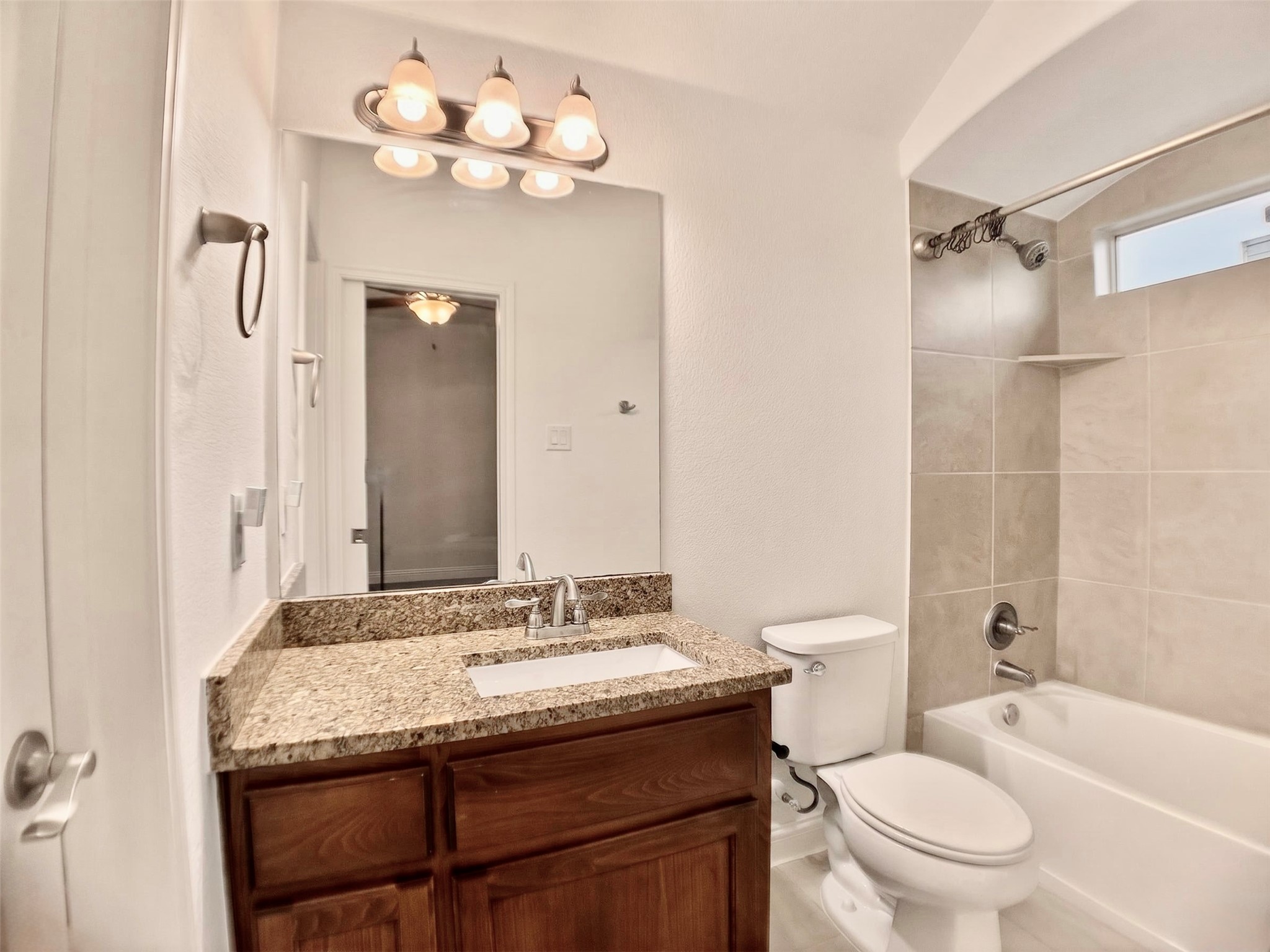 1505 Long Shadow Lane Georgetown, TX 78628 - Photo 21 of 28 Bathroom featuring a wood-finish vanity with a granite-style countertop, undermount sink, and brushed nickel fixtures