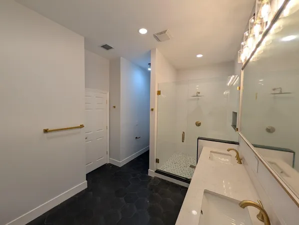 a bathroom with a double vanity sink toilet and mirror