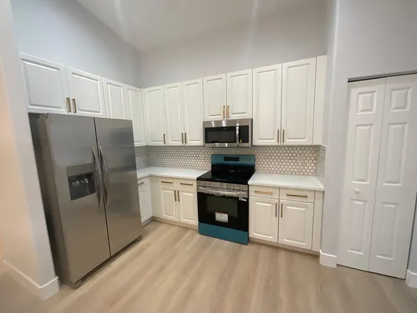 a view of a hallway with wooden floor and a dining room