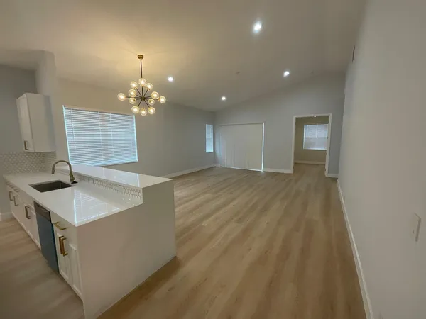 a view of a room with wooden floor and chandelier