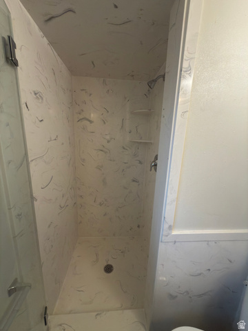 1164 East Mountain Road Logan, UT 84321 - Photo 33 of 45 Walk-in shower with a glass enclosure and a patterned white and gray surround