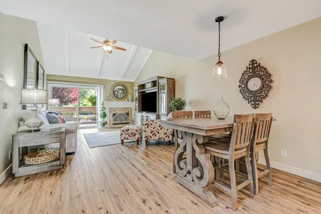 a view of a dining room and livingroom with furniture wooden floor a chandelier