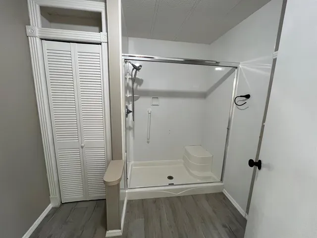 a bathroom with a glass door shower and a sink