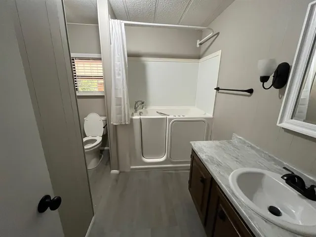 a bathroom with a sink a toilet and shower