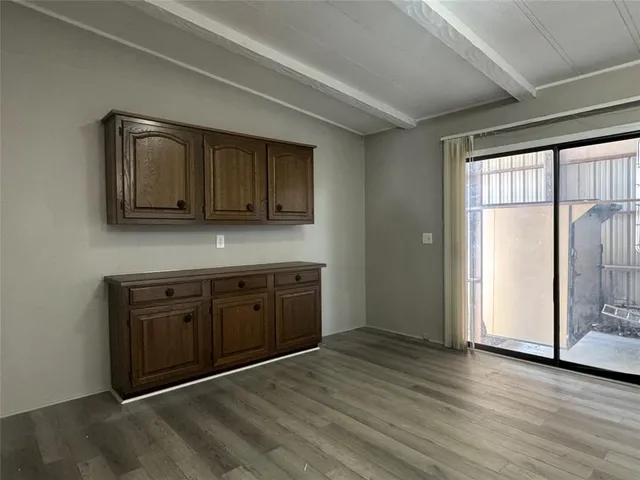 a view of a kitchen with wooden floor and cabinets