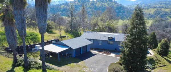 a view of a house with a yard and tree s