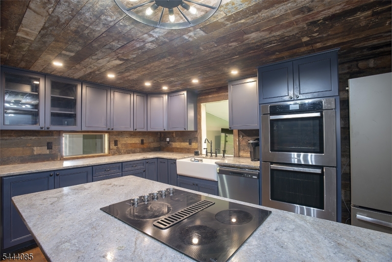 79 Lake Wallkill Road Vernon, NJ 07461 - Photo 4 of 27 a kitchen with a refrigerator a stove and a sink with wooden floor