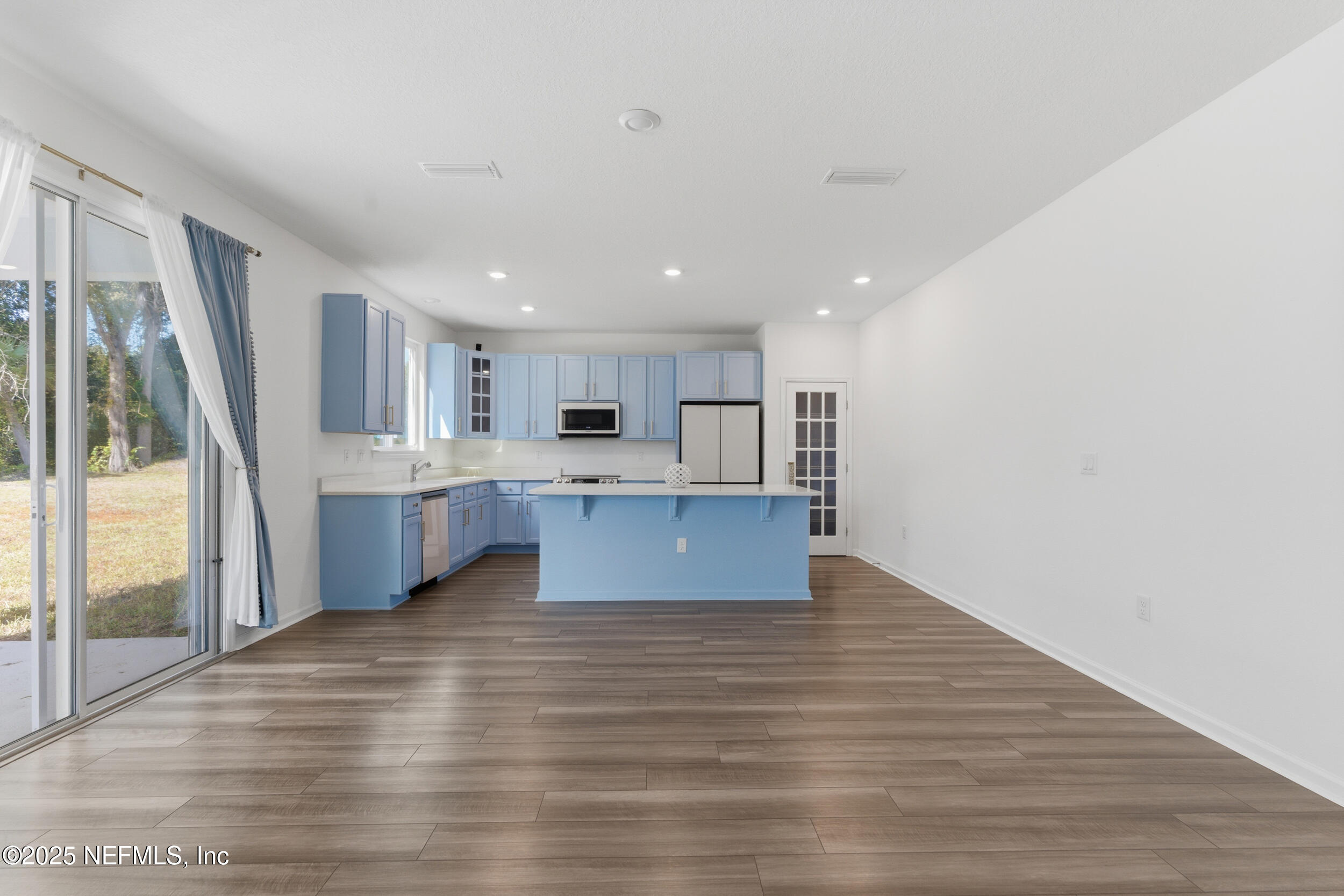 11624 Double Eagle Court Jacksonville, FL 32221 - Photo 11 of 53 a large kitchen with a center island wooden floor and a large window