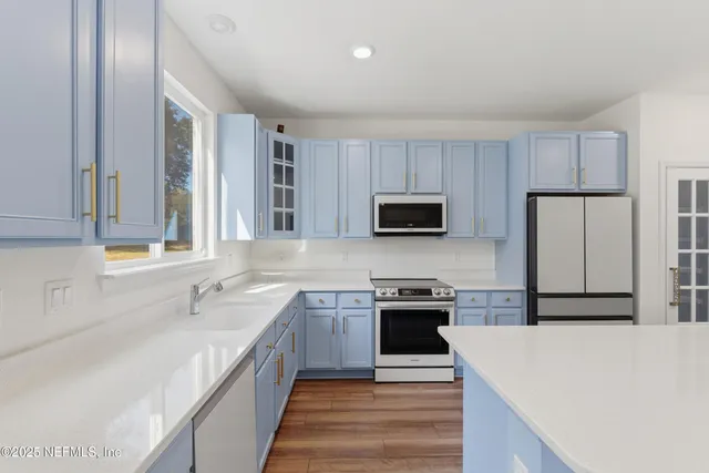 a large kitchen with cabinets appliances and a sink