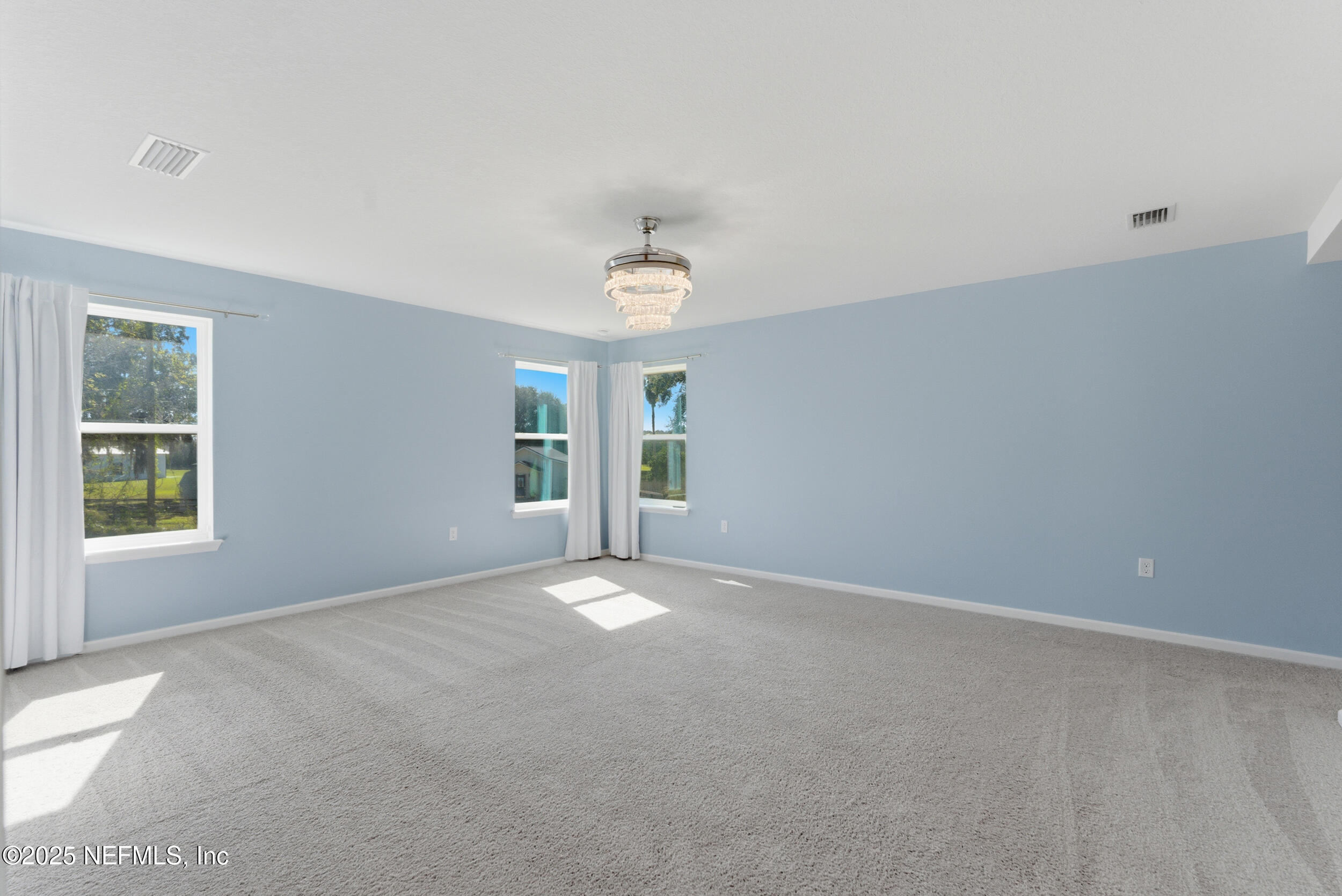 11624 Double Eagle Court Jacksonville, FL 32221 - Photo 21 of 53 an empty room with windows and a chandelier fan