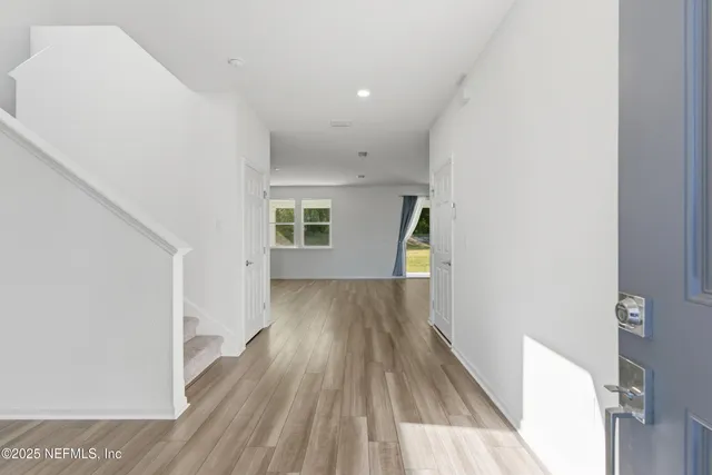 a view of a hallway with wooden floor and staircase