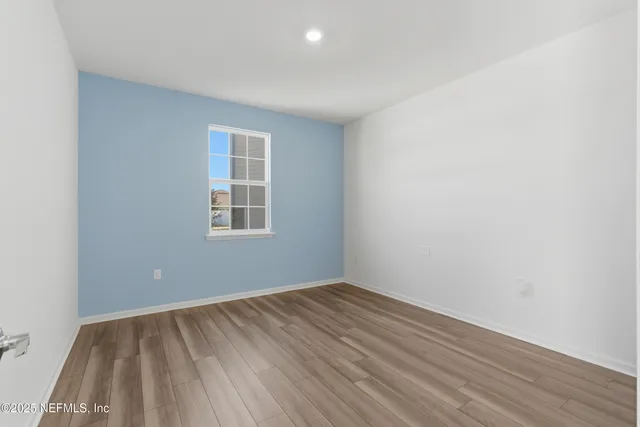 a view of a room with wooden floor and windows