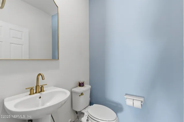 a bathroom with a sink a toilet and mirror