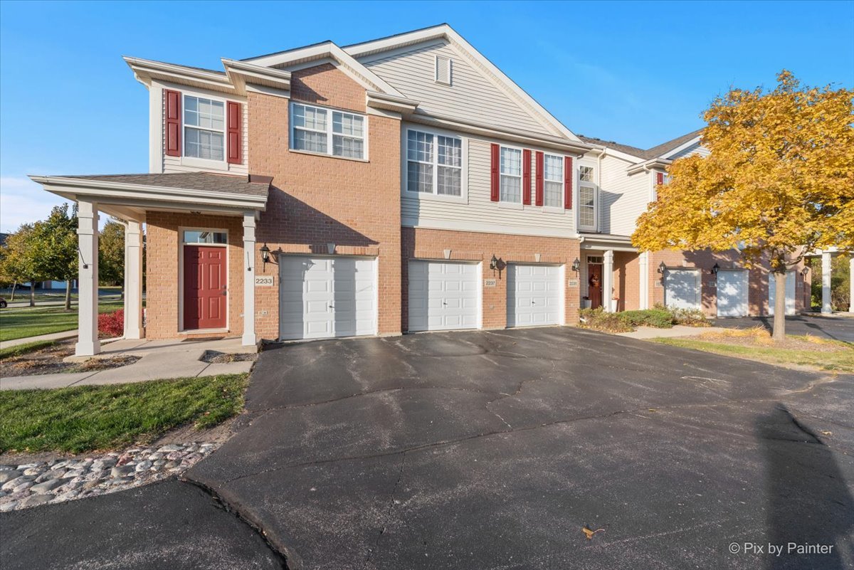 2237 Concord Drive, Unit 2237 McHenry, IL 60050 - Photo 19 of 19 a front view of a house with a yard and garage