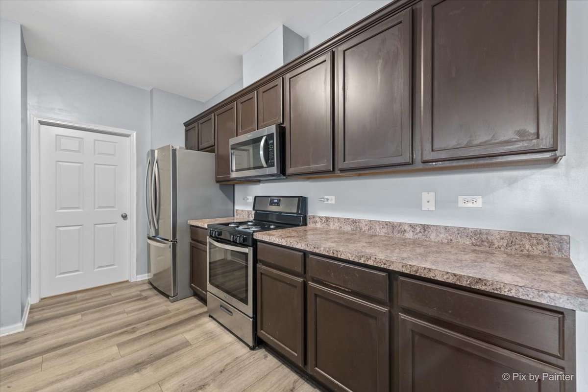 2237 Concord Drive, Unit 2237 McHenry, IL 60050 - Photo 7 of 19 a kitchen with stainless steel appliances granite countertop a sink stove and refrigerator