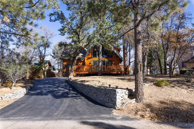 a front view of house with large trees