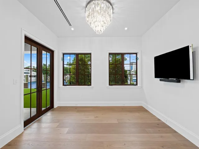 a living room with stainless steel appliances furniture a rug and a kitchen view
