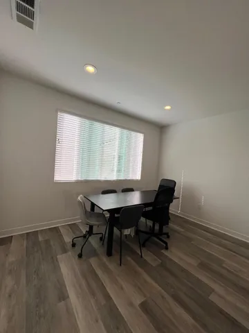 a view of a workspace with furniture and a window