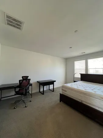 a bedroom with a bed a desk and chair
