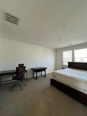 a bedroom with a bed a desk and chair
