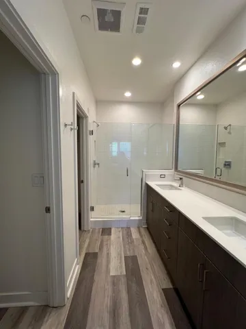 a spacious bathroom with a double vanity sink and mirror