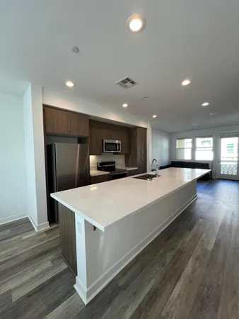 a large room with kitchen island a sink dishwasher and a refrigerator