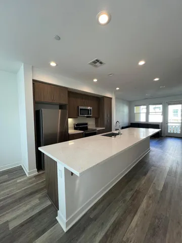 a large room with kitchen island a sink dishwasher and a refrigerator