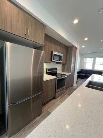 a kitchen with granite countertop a refrigerator and a sink