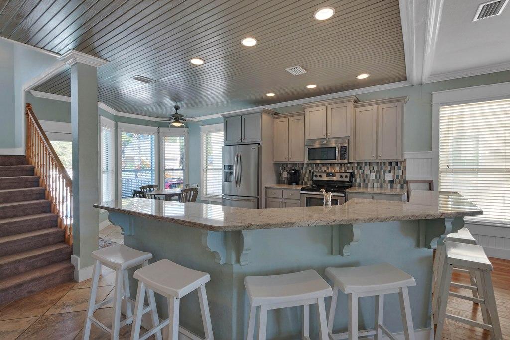 68 Cobia Street Destin, FL 32541 - Photo 12 of 47 a kitchen with stainless steel appliances granite countertop a stove top oven a sink a dining table and chairs