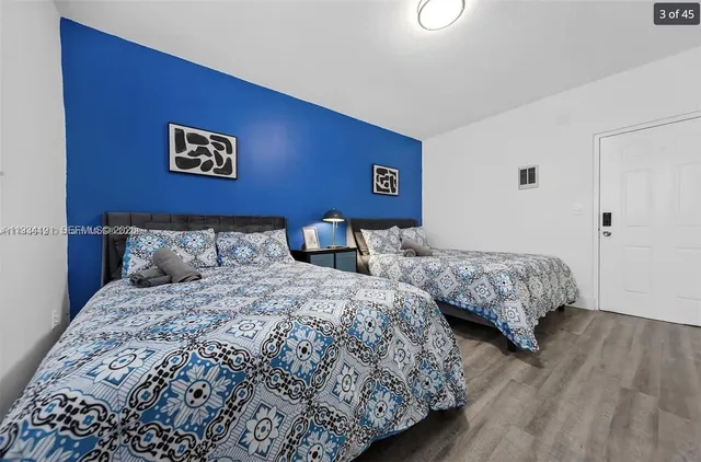 a bedroom with two beds and a lamp on table