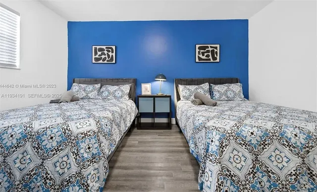 a bedroom with bed and paintings on the wall