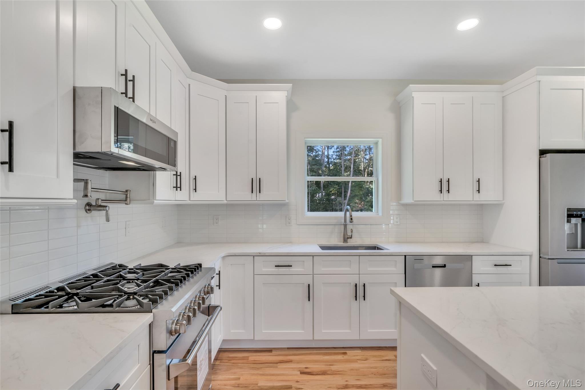 817 Pond View Road Riverhead, NY 11901 - Photo 22 of 36 a kitchen with stainless steel appliances a sink stove and cabinets