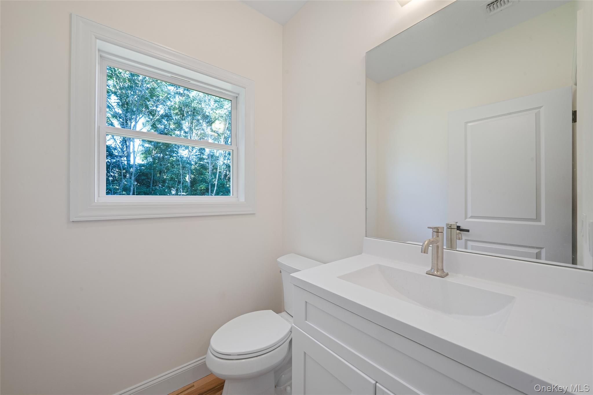 817 Pond View Road Riverhead, NY 11901 - Photo 24 of 36 a bathroom with a sink a toilet and a window