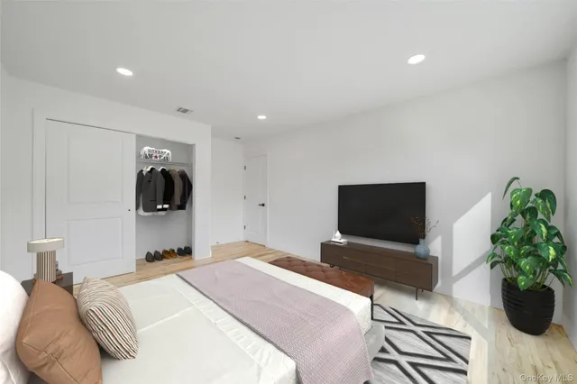 a bedroom with a large bed and a potted plant