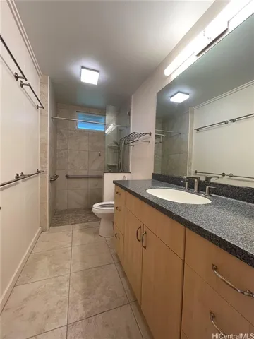 a bathroom with a granite countertop sink a toilet and a shower