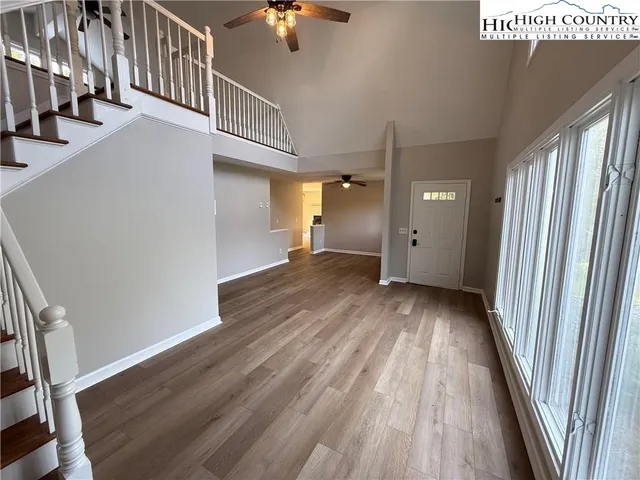 a view of a hallway with wooden floor and staircase