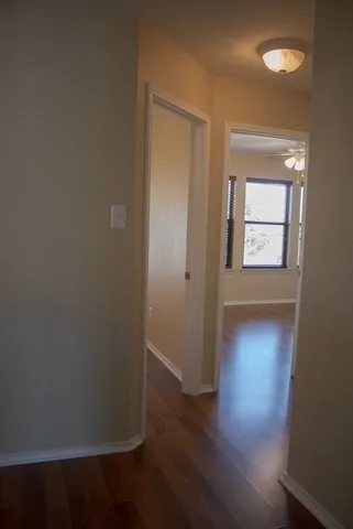 an empty room with wooden floor and a window