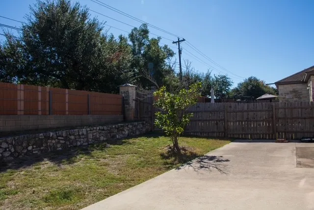 a view of backyard with potted plants and wooden fence