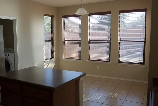 a view of a dining room with a table and chairs