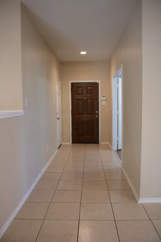 a view of hallway with a window and a refrigerator