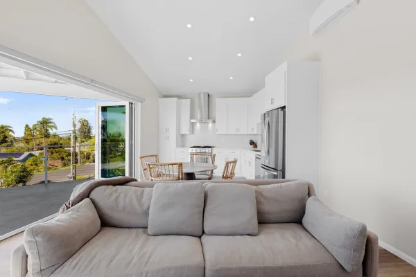 a living room with furniture granite countertop kitchen view and a large window