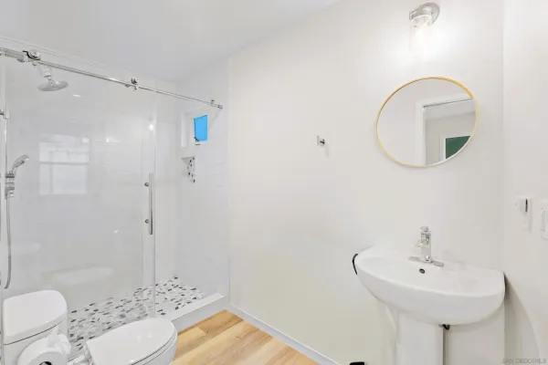 a bathroom with a sink a toilet and shower